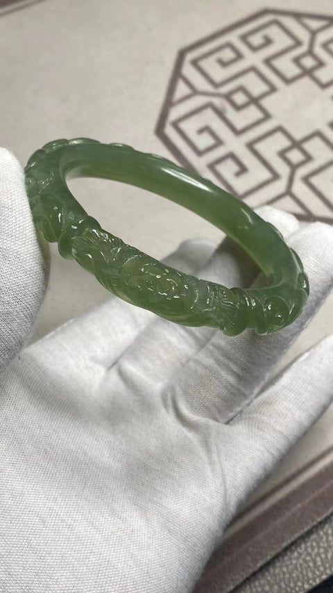 Gelang Bunga Berukir Giok Cui Alami Ukuran 57-59mm Ukuran 58.5mm Lebar Sisi 10.7mm Batu giok terbentuk secara alami dan polanya acak Sudah termasuk ongkos kirim dan pajak.