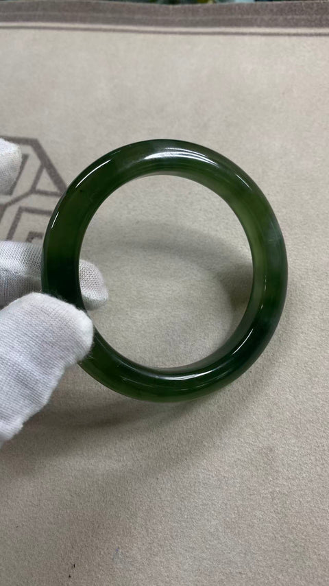 Gelang giok Xiuyan yang indah dengan zamrud hijau cerah, melambangkan kehidupan yang sejahtera. Diameter 59,8 mm, lebar sisi 12 mm. Batu alam terbentuk secara alami, dengan pola acak. Biaya pengiriman dan pajak sudah termasuk