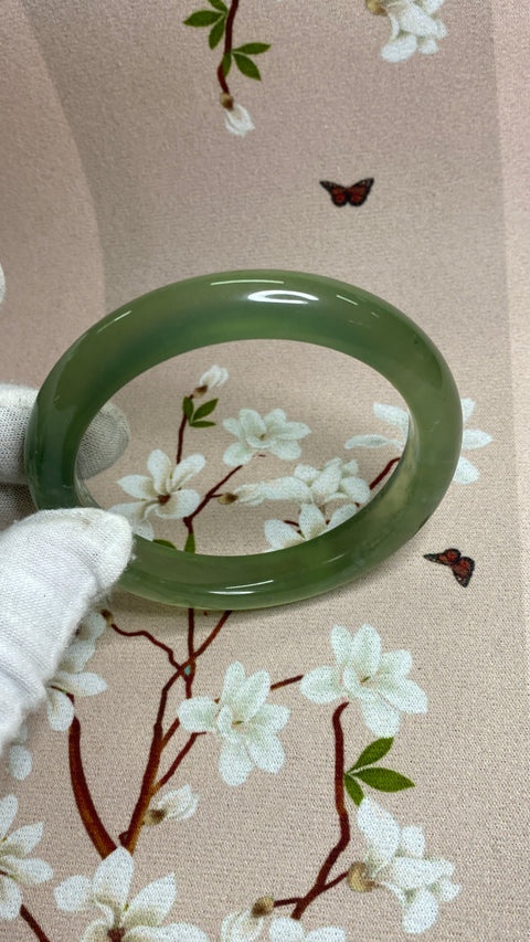 Gelang topi susu hijau giok Xiu yang indah, dengan diameter 63 mm dan lebar samping 11,9 mm. Potongan giok semuanya diproduksi secara alami dengan pola acak. Sudah termasuk pengiriman dan pajak