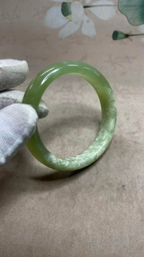 Gelang giok Xiuyan yang indah dengan rona hijau dan tekstur seperti susu, setengah giok dan setengah hijau, diameter dalam: 59,8 mm, lebar tepi: 13 mm. Semua batu terbentuk secara alami. Biaya pengiriman dan pajak sudah termasuk.