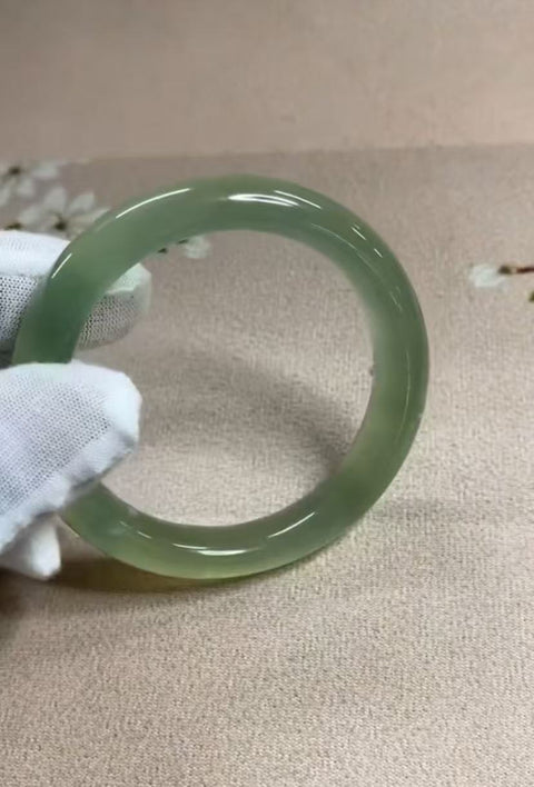 Gelang giok Xiuyan yang indah, dengan semburat hijau yang mengambang di dalamnya. Diameter dalam: 55 mm, lebar tepi: 11,5 mm. Batunya terbentuk secara alami; polanya acak. Biaya pengiriman dan pajak sudah termasuk.