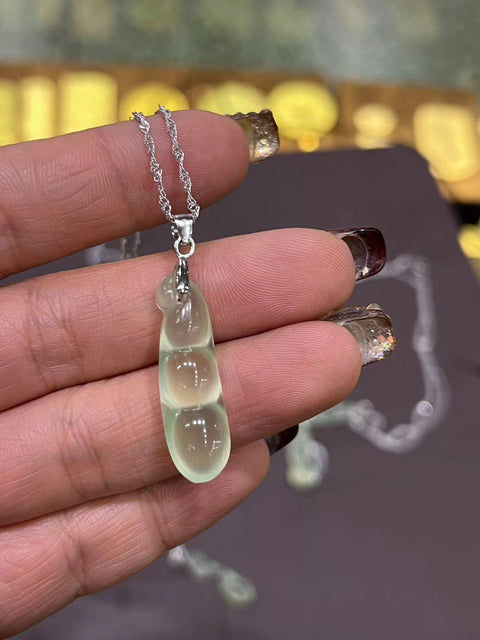 Liontin kacang empat musim dari bahan es giok giok hijau! Pada rantai perak dengan carabiner perak. Ukuran 26mm * 8,5mm. Batu gioknya bersih, halus dan hangat.